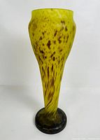 Full front view of the tall yellow and brown mottled satin glass vase, showing tapering shape and blackened base.