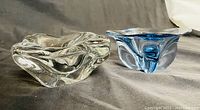 Side-by-side photo of clear and blue accented Murano glass bowls showing flowing transparent designs.