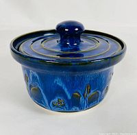 Front angle view of the blue glazed pottery covered dish showing textured pattern and lid knob.