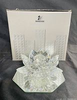 Swarovski crystal candle holder with original box in the background showing Swarovski branding.