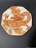 Front view of octagonal bone china Mikasa plate with terracotta dragon design and cloud motifs