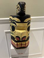 Front view of the carved wooden mask sculpture with painted stylized features