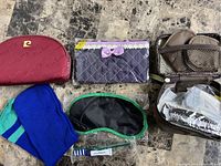 Photo showing all travelling items including cosmetic bags, sleep mask, toothbrush, sock, and travel organizer on a marble surface.
