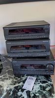 Kenwood stereo system components stacked on marble top including equalizer, cassette deck, and receiver with visible control buttons and display screens.