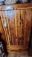 Front view of a cedar wood closet with distinct vertical wooden panels and natural wood knots.