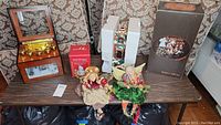 Full view of all items including music boxes, boxed Elderly Elves of Adler, and two fairy figurines placed on a wooden surface