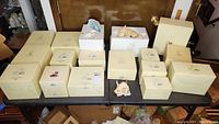 Table display of multiple Lenox boxes including cat figurines, votive holder and Disney figurine