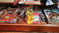 Wide shot showing cowboy boots, belt, bandana, boxed items, and small Roy Rogers figurine with dog