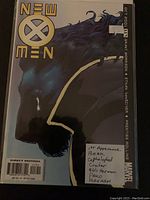 Front cover of New X-Men comic book featuring character in profile and New X-Men logo, with handwritten note about first appearances of characters.