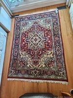 Top-down view of full rectangular wool area rug showing overall pattern, colors, fringe and condition