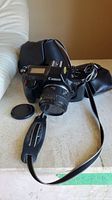 Photo showing Canon EOS 650 camera with 50mm lens and carrying case in background