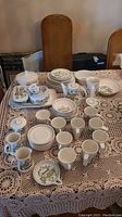 Full assortment of plates, bowls, cups and serving pieces laid out on table