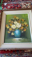 Framed original painting of flowers in a blue vase on a green background, showing full artwork and frame.