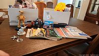 Full lot of photography manuals, booklets, and figurines on a wooden table.