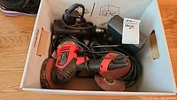 Bosch PW5 5-115 angle grinder with power cord inside white box alongside other tools