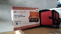 Original box of Outbound 2-burner propane camping stove, bilingual English and French text on box.