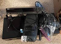 Overview of all electronic devices showing cables and remote placed on top, with numbered tag on portable radio.