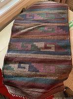 Overall view of a woven mat showing geometric pattern and colors