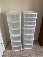 Front view of two tall plastic drawer units with six translucent drawers each, white plastic frame tops.