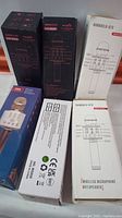 Photo showing six boxed wireless handheld karaoke microphones with factory packaging labeled WS-858H and KTV handheld microphone.