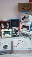 Overview of ten sealed retail boxes of controllers and accessories