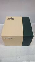 Closed beige and dark green Casio Pro Trek branded watch box on a surface