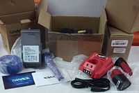 Photo displaying entire lot including charger, Dyson battery, blue component, and packaging.