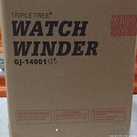 Photo of cardboard box showing Triple Tree Watch Winder logo and model number GJ-14001US.