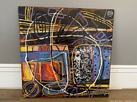 Front view of the 24x24 inch abstract painting showing geometric lines and shapes in multiple colors on a black background.