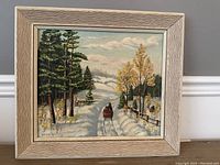 Framed oil painting on board showing a winter scene with a horse-drawn sleigh on a snowy path surrounded by trees.