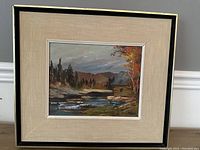 Framed oil on board landscape painting by Walter Pranke showing natural scenery including river, trees, cabin, and autumn foliage.