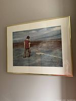 Framed lithograph showing a young man holding a baseball glove at a baseball base, in a gold frame.