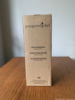 Packaging box for Pampered Chef electric wine opener showing brand and product details.
