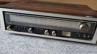 Front view showing the Luxman R-1030 receiver with tuning scale, knobs, and input jacks.