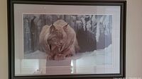 Full view of framed print showing lynx sitting in snow with snow-covered trees in background and dual matting in frame.