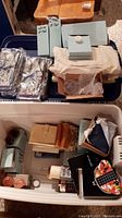 Photo showing multiple vanity bags in plastic bags, stacked boxes labeled pillar candles, and some smaller box packages.