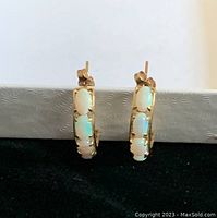 Front view of both earrings standing upright against a white and black background