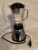 Full assembled view of the blender with glass jar, lid and power cord visible.