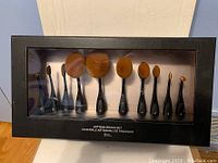 Front view of the closed boxed set showing all 10 brushes with black handles and brown bristles arranged by size.