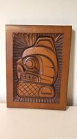 Front view of the wooden beaver plaque showing detailed hand-carved design in rectangular wood panel.