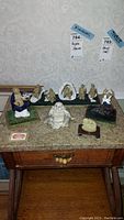 Photo showing entire set of nine Buddha and monk figurines including jade pendant