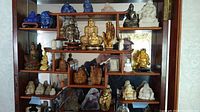 Front view of wooden display cabinet with all figurines arranged across multiple shelves