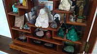 Wooden display shelf with assortment of Buddha figurines and trays