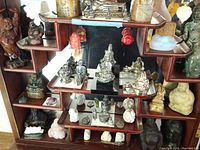 Overall view of wooden display with Buddha figurines in various materials