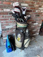 Overall view of golf bag filled with clubs and small blue accessory bag