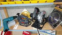 Overview photo showing all three power tools on shelf with blades and bits nearby.