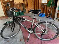 Side view of the silver Trek Navigator 100 men's bicycle showing frame, wheels, seat, kickstand, and handlebars