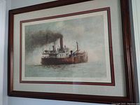Front view of framed ship-themed color lithograph matted in ivory and burgundy within wood-tone frame