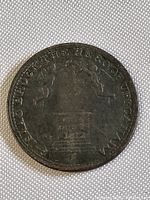 Obverse side of the 1812 Upper Canada coin token showing dated imagery and inscriptions, heavily circulated and darkened surface.