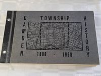 Front cover of the Camden Township History book showing black and grey map of the township with title text and three holes for binder.
